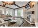 Inviting living room featuring a stone fireplace, wood-beamed ceiling, and large windows that fill the room with natural light at 5518 Morris Hunt Dr, Fort Mill, SC 29708