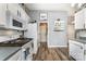 Well-equipped kitchen featuring white cabinets, stainless steel appliances, and wood-style floors at 5829 Andrew Ward Ave, Charlotte, NC 28216