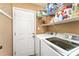 Laundry room features modern washer and dryer, shelving, and an exterior door at 5829 Andrew Ward Ave, Charlotte, NC 28216