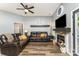 Cozy living room with a fireplace, modern ceiling fan, and comfortable leather sofas at 5829 Andrew Ward Ave, Charlotte, NC 28216