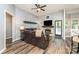 Well-lit living room with a modern fireplace, dark wood floors, and access to the kitchen and entry at 5829 Andrew Ward Ave, Charlotte, NC 28216