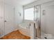 Bathroom featuring a soaking tub with a window view and a separate glass-enclosed shower at 6532 Prosperity Commons Dr, Charlotte, NC 28269