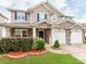 Attractive two-story home with stone accents, a blue front door, and landscaped garden beds at 6532 Prosperity Commons Dr, Charlotte, NC 28269