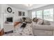 Cozy living room with a fireplace, plush sofas, and abundant natural light from large windows at 6532 Prosperity Commons Dr, Charlotte, NC 28269