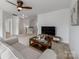 Bright living room with a ceiling fan, plush carpeting, and cozy seating area at 6532 Prosperity Commons Dr, Charlotte, NC 28269
