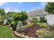 Beautifully landscaped backyard featuring a stone-edged garden, mulched beds, and a serene outdoor ambiance at 7130 Maricopa Rd, Charlotte, NC 28277