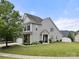 A well-maintained house with grey siding, a green lawn, and mature landscaping, showing off its curb appeal at 7130 Maricopa Rd, Charlotte, NC 28277