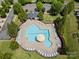 An aerial view of a community pool with many lounge chairs and tables under mature shade trees and a small building nearby at 7130 Maricopa Rd, Charlotte, NC 28277