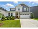 Charming two-story home features a red door, manicured lawn, and a two-car garage on a sunny day at 9930 Cask Way, Huntersville, NC 28078