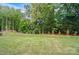 A view of the home's expansive backyard with many trees and a partial fence at 9957 Cask Way, Huntersville, NC 28078