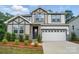 Charming two-story home with stone accents, a well-manicured yard and a two car garage at 9957 Cask Way, Huntersville, NC 28078