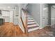 Beautiful staircase featuring wood treads, white risers and spindles, and newel post at 9957 Cask Way, Huntersville, NC 28078