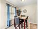 Dining area featuring a modern table, natural light from window, and stylish window treatments at 10063 Reindeer Way Ln, Charlotte, NC 28216