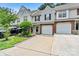 Attractive townhome with attached garages, manicured lawn, and gray siding that provides a welcoming street view at 10063 Reindeer Way Ln, Charlotte, NC 28216