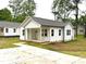 Charming white home with a cozy front porch and a long concrete driveway at 1102 Grady St, Salisbury, NC 28144