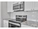 Modern kitchen with stainless steel oven and microwave, granite countertops, and white cabinets at 1102 Grady St, Salisbury, NC 28144