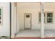 A covered front porch featuring brick detail and a storm door with glass panes and white posts at 1102 Grady St, Salisbury, NC 28144