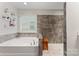 Bright bathroom featuring a soaking tub, walk-in shower with bench and rain shower and stone-look tile floor at 1306 San Gabriel Ave, Charlotte, NC 28214