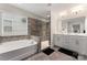Bright bathroom featuring a soaking tub, walk-in shower, double sink vanity and stone-look tile floor at 1306 San Gabriel Ave, Charlotte, NC 28214