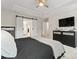 Comfortable bedroom features tray ceilings, a ceiling fan, a wall-mounted TV, and barn doors to the bath at 1306 San Gabriel Ave, Charlotte, NC 28214