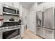 Modern kitchen with stainless steel appliances, white cabinets, and light wood flooring at 1306 San Gabriel Ave, Charlotte, NC 28214