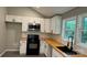An eat-in kitchen features white cabinets and stainless steel appliances and black fixtures at 148 Forest Heights Dr, Mcadenville, NC 28101