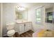 Bathroom with wood-look flooring, pink vanity, large mirror and wallpaper at 155 Springdale Acres Dr, Mooresville, NC 28115