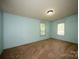 Simple bedroom with carpet floors, light blue walls, and natural light from two windows at 155 Springdale Acres Dr, Mooresville, NC 28115