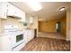 Kitchen and dining area with light filled view; white appliances and cabinetry and wood-look flooring at 155 Springdale Acres Dr, Mooresville, NC 28115