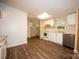 Bright kitchen featuring white cabinets, countertops and appliances with updated wood-look flooring at 155 Springdale Acres Dr, Mooresville, NC 28115