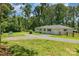 This beautiful single-story home is surrounded by lush greenery and features a long driveway at 1632 Charles Raper Jonas Hwy, Mount Holly, NC 28120