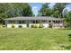 Charming single-story home with blue shutters and a well-manicured lawn at 1632 Charles Raper Jonas Hwy, Mount Holly, NC 28120