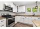 Close-up of a kitchen highlighting stainless steel appliances, granite countertops, and ample cabinet space at 1632 Charles Raper Jonas Hwy, Mount Holly, NC 28120
