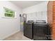 This laundry room features new appliances, shelving, and a window for natural light at 1632 Charles Raper Jonas Hwy, Mount Holly, NC 28120