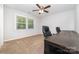 This carpeted home office features a ceiling fan, a desk, and a window for natural light at 1632 Charles Raper Jonas Hwy, Mount Holly, NC 28120