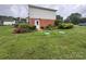 Backyard view showcasing a brick exterior, lush garden, and well-maintained lawn at 1895 Sandy Cir, Newton, NC 28658