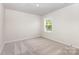 Carpeted bedroom showcasing ample natural light from a window and neutral decor at 2051 Sadler Woods Ln, Charlotte, NC 28214