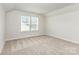 Bright bedroom features neutral carpet, light walls, and a window allowing natural light at 2051 Sadler Woods Ln, Charlotte, NC 28214