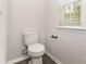 Bright bathroom featuring toilet with black hardware, window, and tile flooring at 2051 Sadler Woods Ln, Charlotte, NC 28214