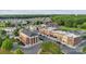 A high angle view shows a charming community with brick buildings, lush trees, and convenient parking at 21013 Running Creek Dr # 4, Locust, NC 28097