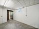 Unfinished basement featuring concrete block walls, drop ceiling, and door leading to storage at 220 Lakeview Dr, Belmont, NC 28012