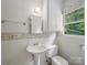 Bright bathroom featuring a pedestal sink, toilet, and a window for natural light at 220 Lakeview Dr, Belmont, NC 28012