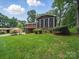 Rear of brick home showcasing a screened porch and lush green yard at 220 Lakeview Dr, Belmont, NC 28012