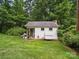 Exterior view of shed showing white siding and windows surrounded by lush greenery at 220 Lakeview Dr, Belmont, NC 28012