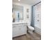 A well-lit bathroom features a vanity with sink, toilet, and shower with blue patterned curtain at 2485 Hedgecliff Rd, Kannapolis, NC 28025