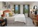 A cozy bedroom featuring a bed with stylish decor, complemented by natural light from the windows at 2485 Hedgecliff Rd, Kannapolis, NC 28025