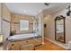 A luxurious bathroom features a tiled tub with a glass panel, wood floors, and an elegant mirror at 3500 Sunningdale Ln # 221, Statesville, NC 28625
