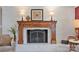 A cozy fireplace with decorative mantel on a white brick wall and hearth creates a warm ambiance in the home at 3500 Sunningdale Ln # 221, Statesville, NC 28625