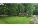 Modest brick home with a lush green lawn, framed by mature trees and shrubs at 3715 Patricia Nw Dr, Concord, NC 28027