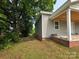 Side view of a home featuring gray siding, a brick foundation, and a covered porch with wooden ceiling at 38 Holly St, Great Falls, SC 29055